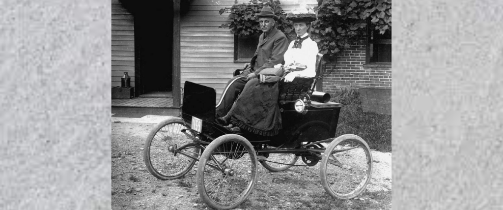 Black and white photo of couple in an early EV