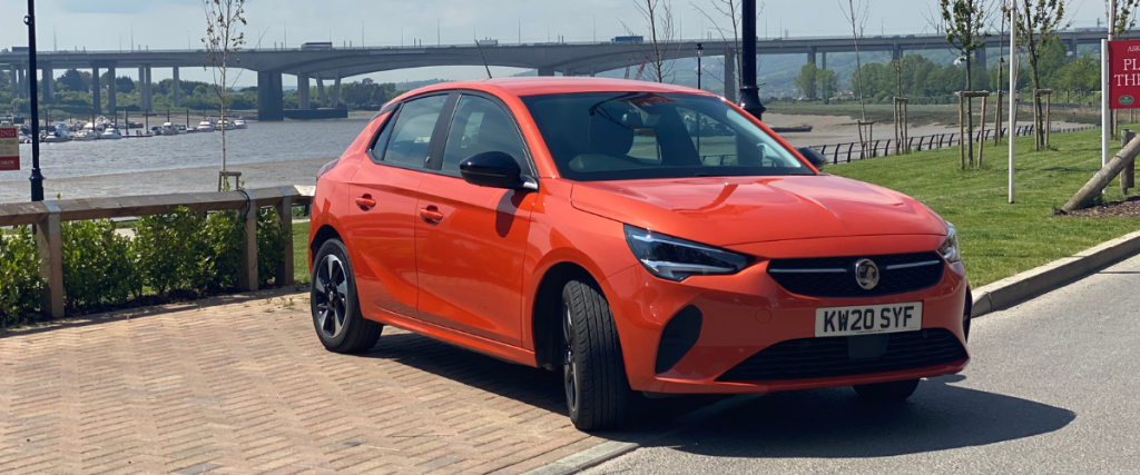 Orange Vauxhall Corsa-e with bridge in background